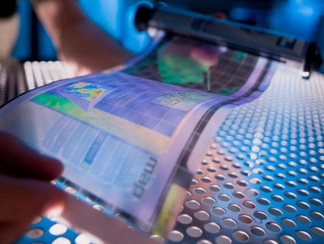 Individual examining information printed on semi transparent, flexible film.
