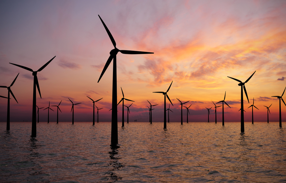 An offshore wind turbine farm at sunset.
