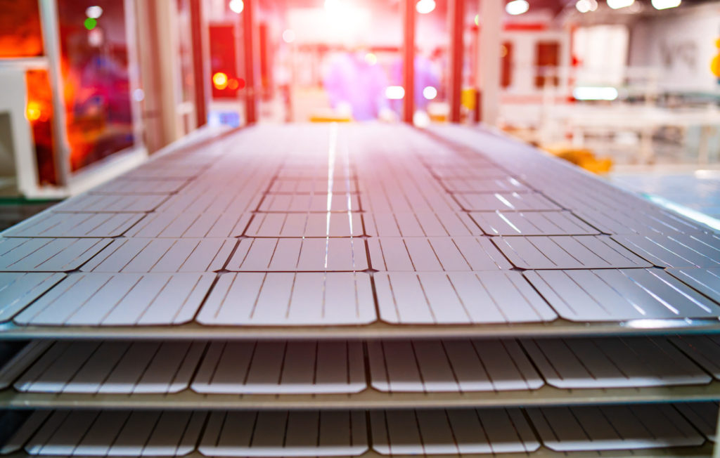 Solar panels stacked up in a production facility.