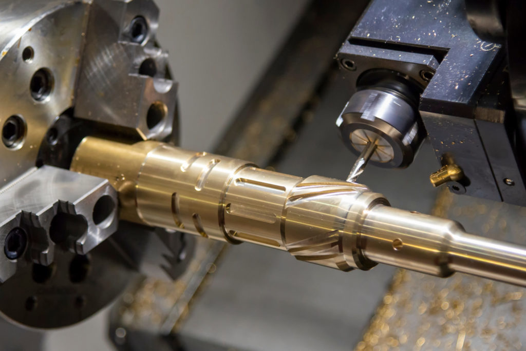CNC lathe machining a complex part from brass.