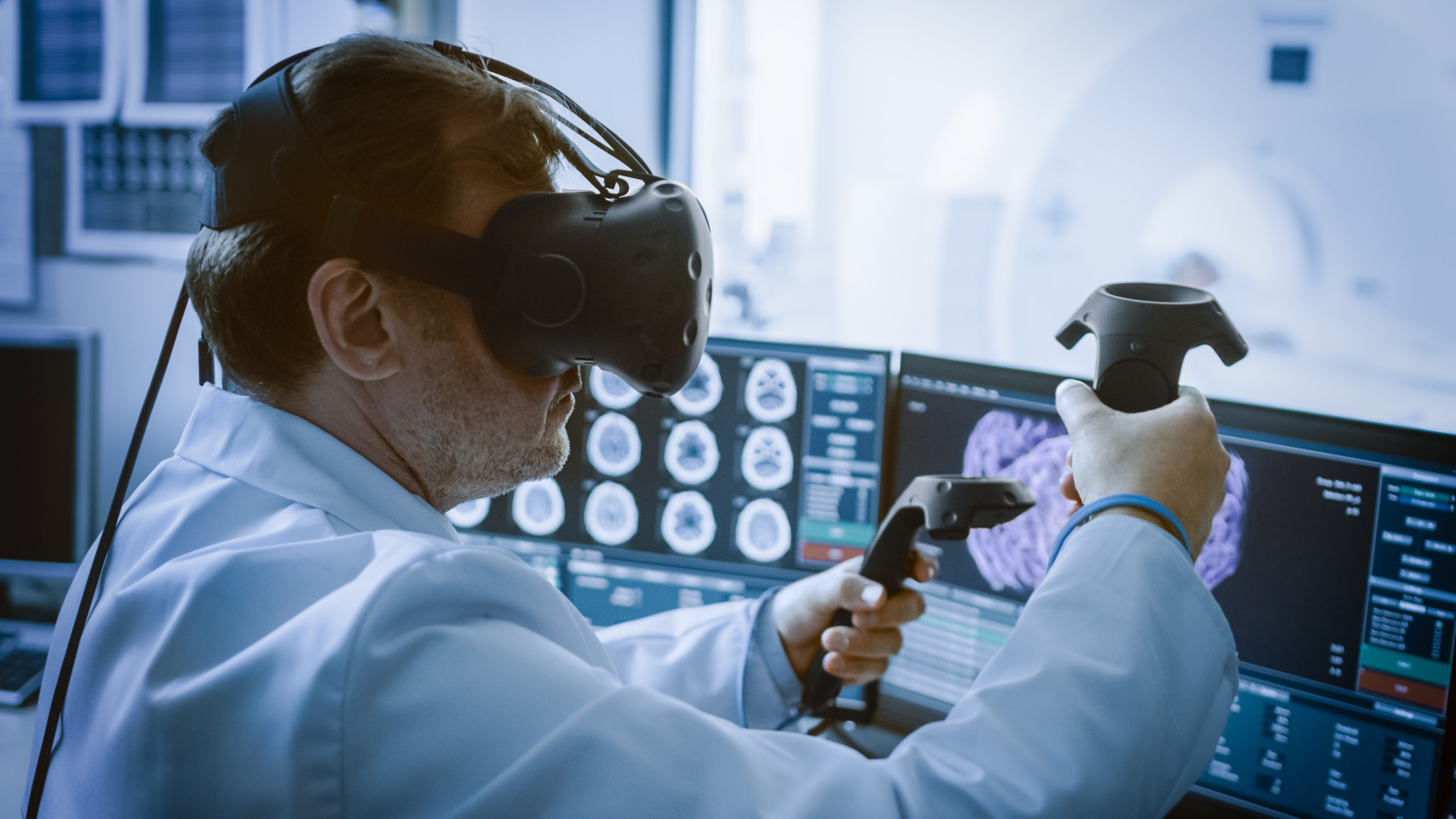 Surgeon wearing virtual reality headset uses controllers to remotely operate patient with medical robot